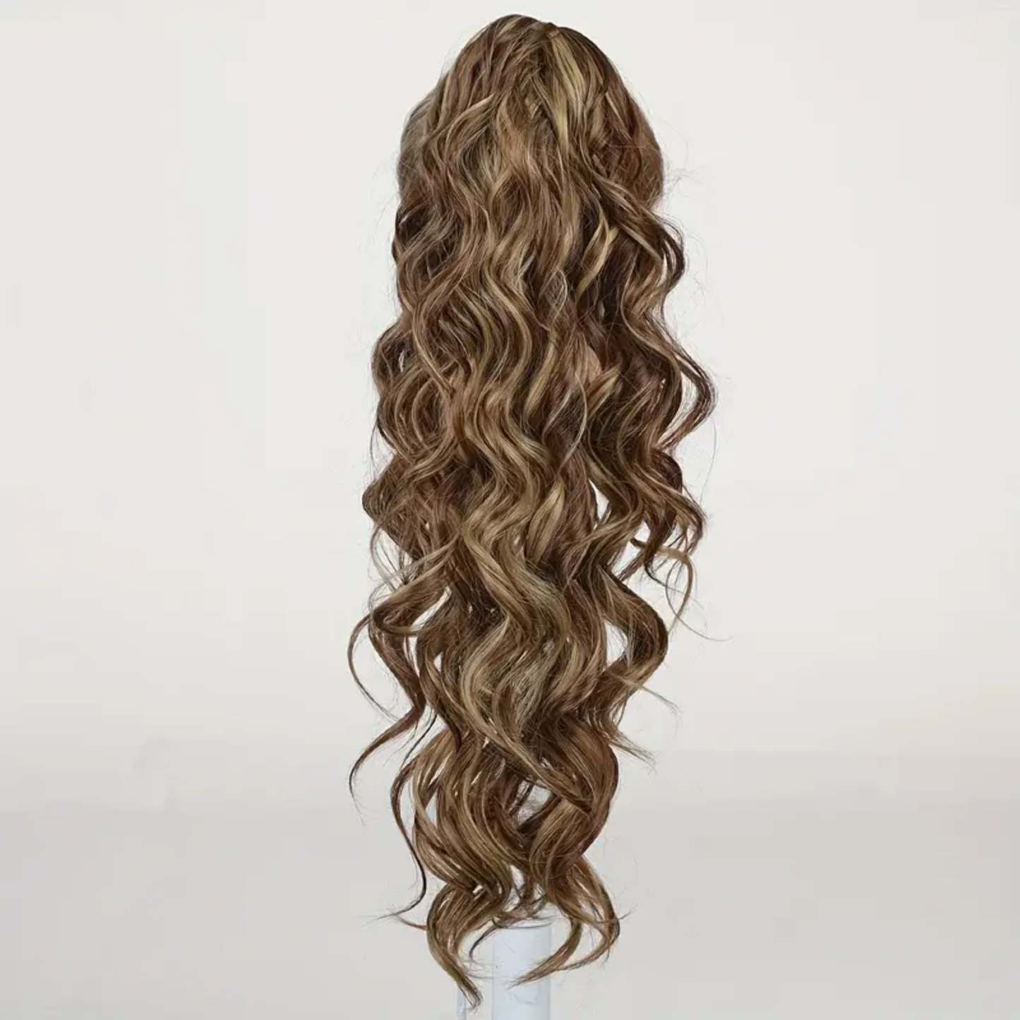 22-inch long wavy synthetic claw clip ponytail hair extension featuring highlighted brown to light brown tones for an instant voluminous and natural-looking hairstyle.
