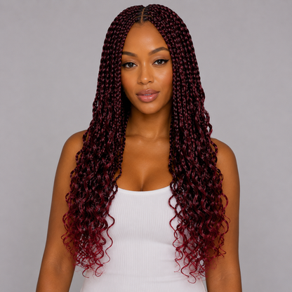 Woman with long, curly burgundy hair against a gray background