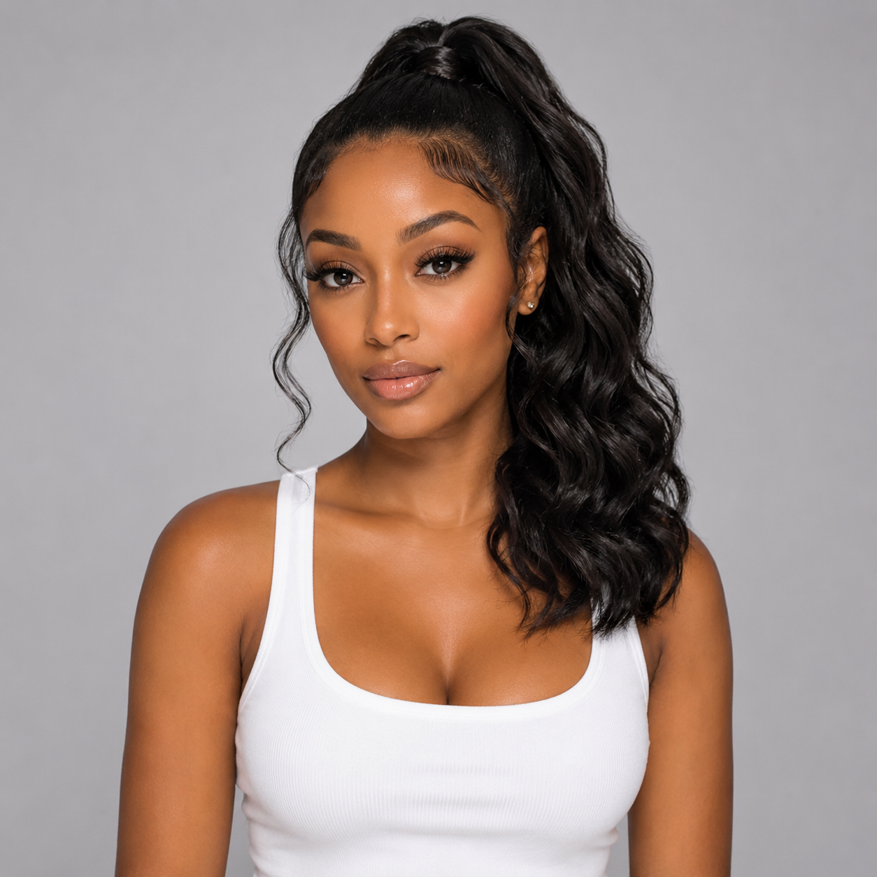 Woman with styled hair wearing a white tank top against a gray background
