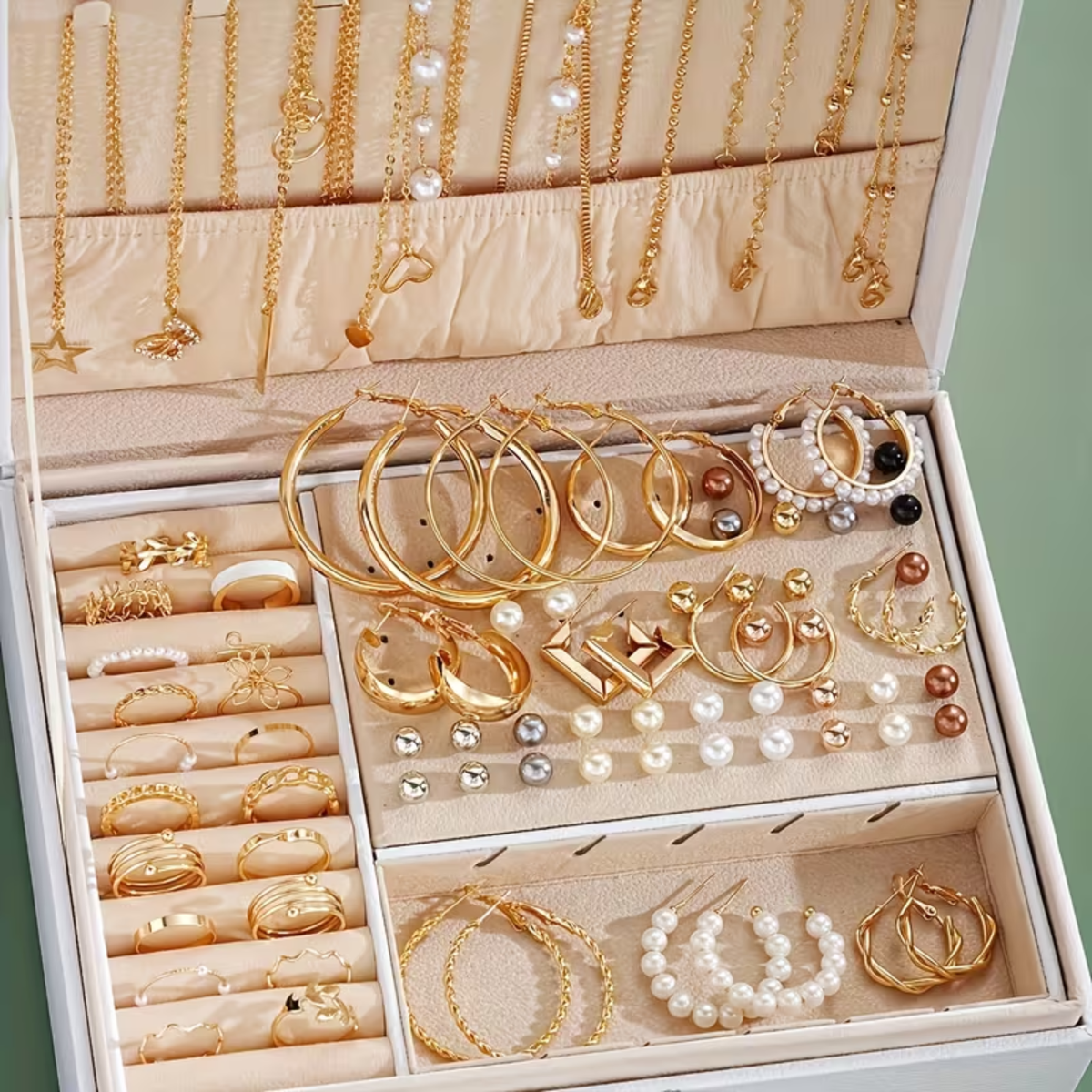 Jewelry organizer with gold and pearl necklaces, bracelets, and earrings.